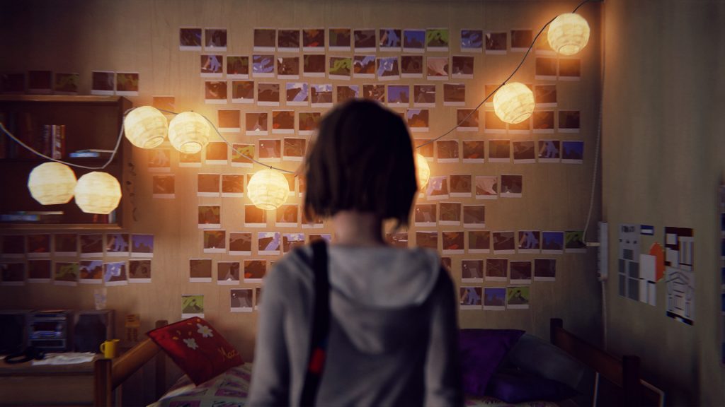 Max de dos devant le mur de photographies de sa chambre
