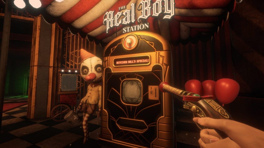 La machine The Real Boy Station, rouge et blanche, un mannequin au visage blanc et au nez rouge à gauche, une main tenant un pistolet doré