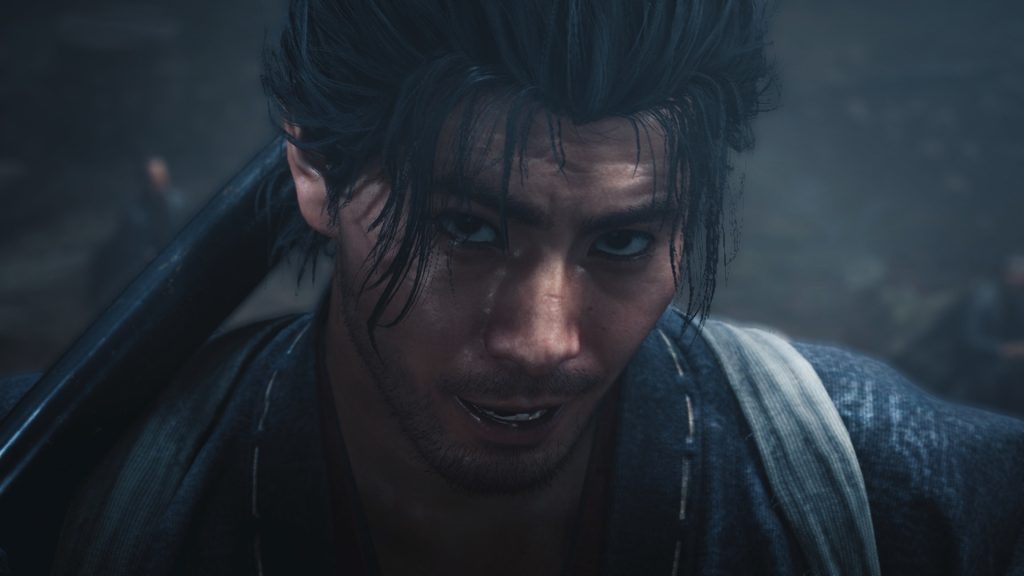 Gros plan sur le visage de Musashi, cheveux noirs en bataille et regard levé, dans une lumière froide