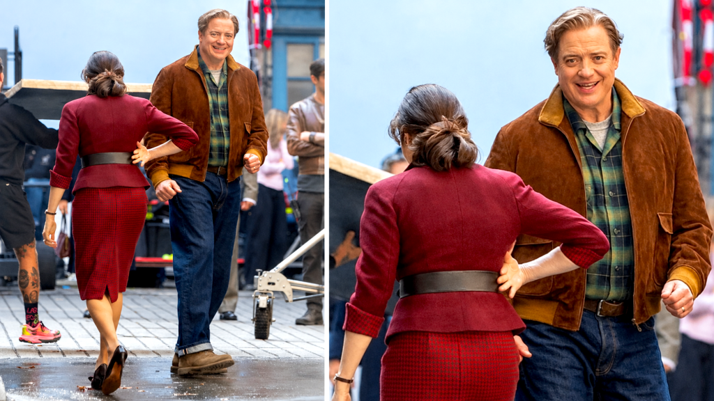 Brendan Fraser et Rachel Weisz sur le tournage, lui en veste de daim marron, elle en tailleur bordeaux : ils marchent dans une rue, puis se font face en souriant.