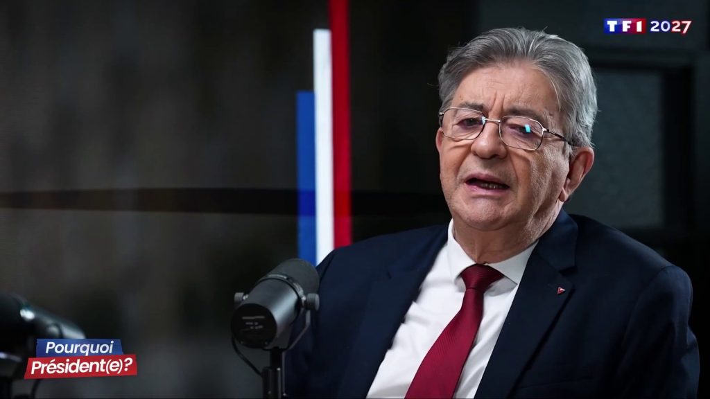 Jean-Luc Mélenchon, en costume sombre et cravate rouge, parle devant un micro sur le plateau de l'émission Pourquoi président(e) ?, dont le titre s'affiche en bas à gauche.