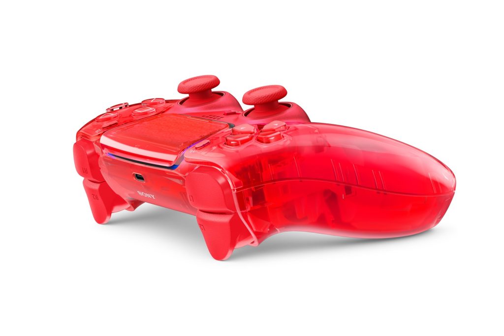 Une manette DualSense rouge transparente vue de profil, sur fond blanc. On distingue les composants à travers la coque.