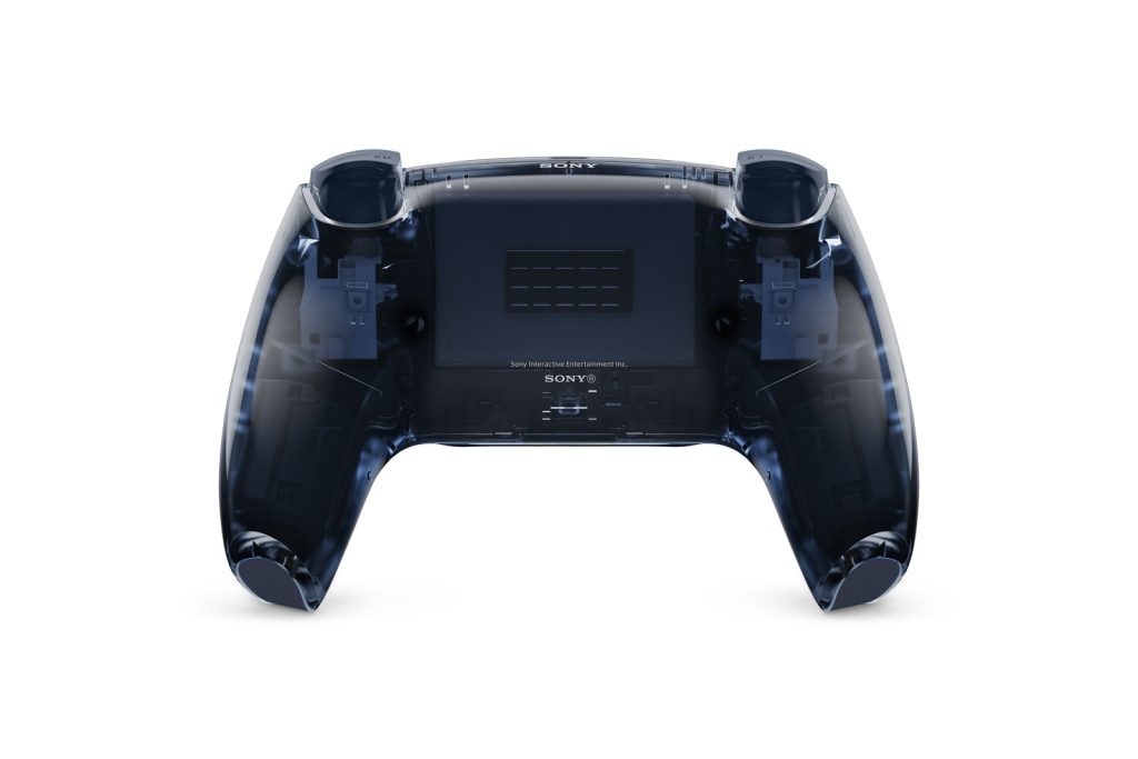 Le dos d’une manette DualSense gris bleuté transparente, sur fond blanc. La coque laisse voir les gâchettes, les vis et la batterie.