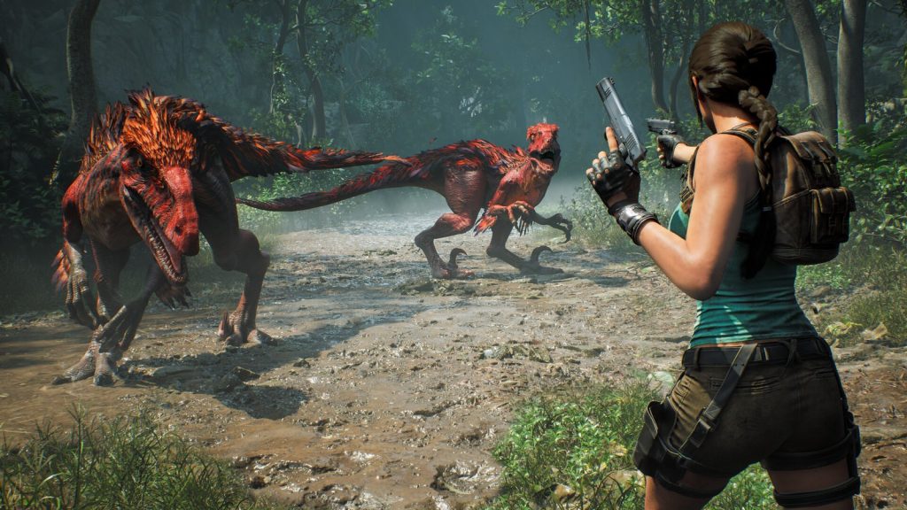 Lara Croft, pistolets en main, fait face à deux dinosaures rouges sur un chemin boueux de jungle.