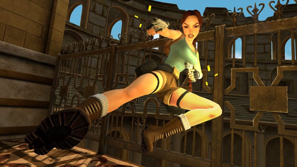Lara Croft saute en tirant avec deux pistolets devant une grille en fer forgé, dans un décor de palais.