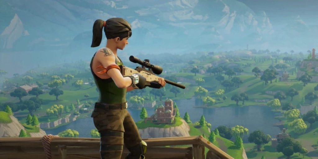 Une combattante de Fortnite, fusil de précision en main, observe depuis une hauteur une île verte parsemée de bâtiments.