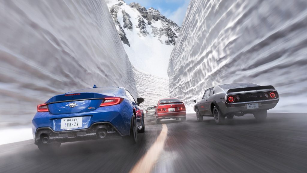 Quatre voitures se suivent dans un couloir de neige aux parois plus hautes qu'elles.