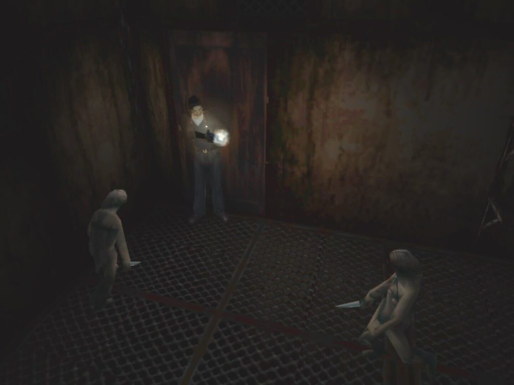 Dans Silent Hill sur PlayStation, un homme tient sa lampe allumée dans une pièce sombre aux murs rouillés, face à deux créatures armées de couteaux.