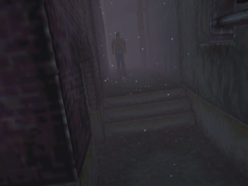 Une ruelle étroite entre deux murs de briques, sous des flocons, où une silhouette marche vers le fond dans un brouillard gris, dans Silent Hill sur PlayStation.
