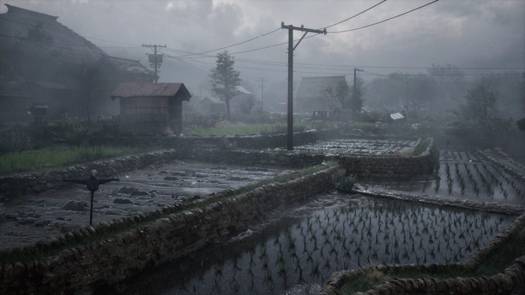 Des rizières en terrasses et un épouvantail dans un village japonais de Silent Hill f, sous des poteaux électriques, dans une brume grise.