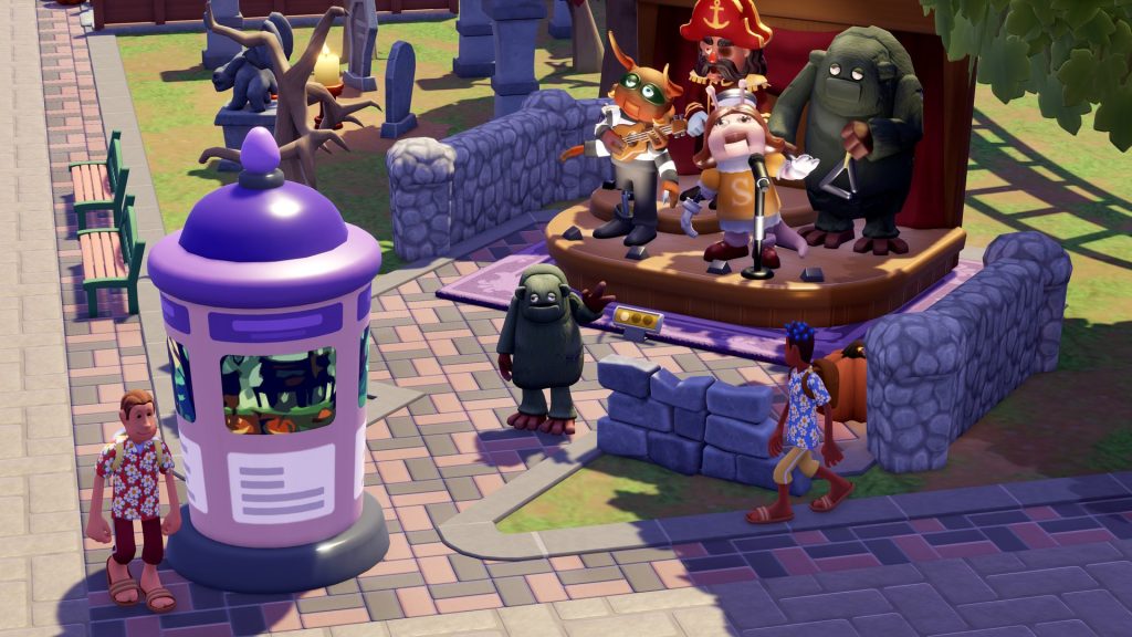 Trois mascottes costumées, dont un pirate et un monstre vert, jouent sur une petite estrade devant des visiteurs.