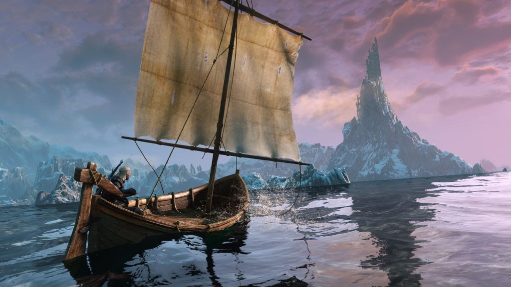 Une barque à voile glisse sur une mer calme vers un rocher pointu, sous un ciel rose au lever du jour.